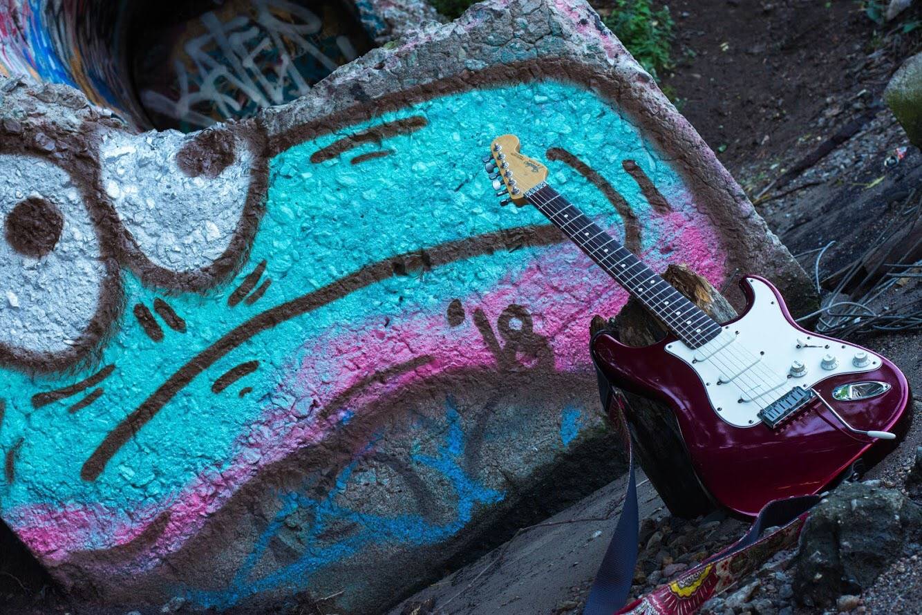 guitar laying against a rock